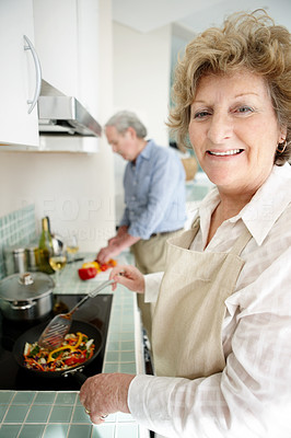 Happy senior couple preparing food in the kitchen