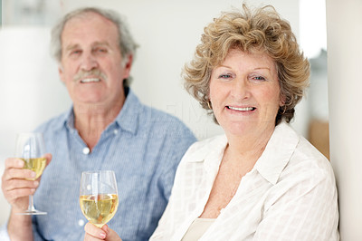 Happy old lady drinking wine with her husband