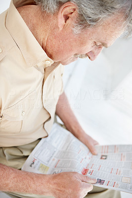 Portrait of a retired senior man reading newspaper
