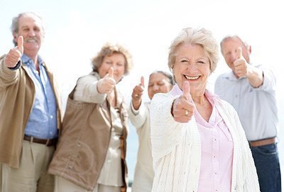 Charming old female showing thumbs up sign with her friends