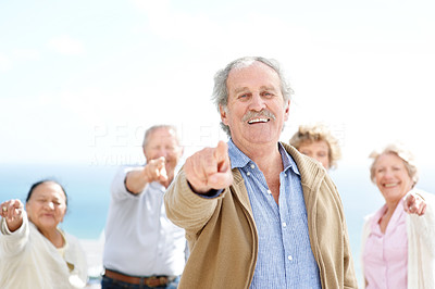 Happy old man pointing at you with his friends