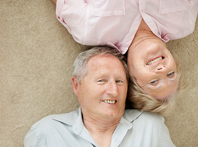 Cute senior couple lying down with their heads together
