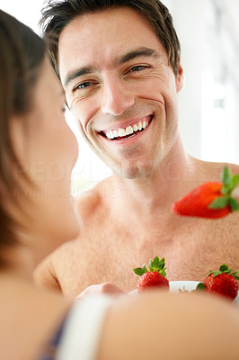 Happy young couple eating strawberries together