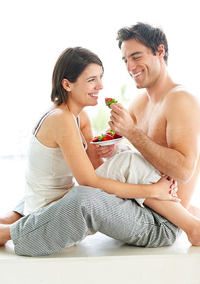 Sweet young couple eating strawberries together