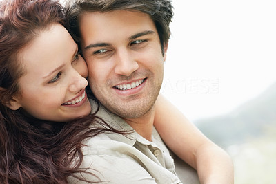 Closeup of a smiling female hugging a man from behind
