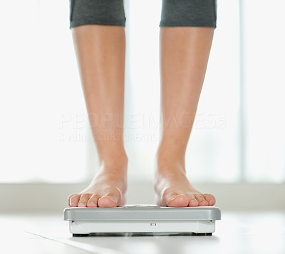 Low section of a woman on a weighing scale