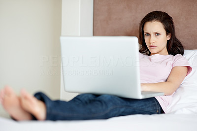 Young woman using laptop on bed - Indoor