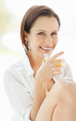 Pretty young woman drinking a glass of juice