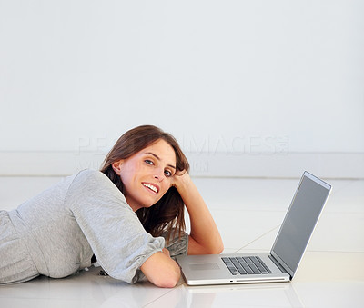Young female lying on floor with laptop