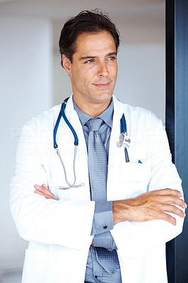 Thoughtful doctor with arms folded looking away
