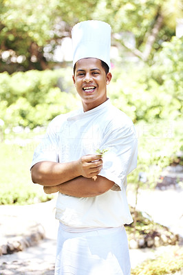 Handsome young chef standing in garden