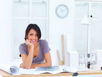 Female architect with blueprints smiling in an office
