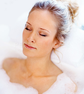 Portrait of a beautiful young woman relaxing in a bath tub