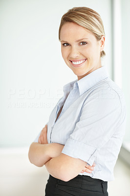 Happy confident young female executive stands with hands folded