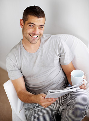 Portrait of relaxed young guy with newspaper