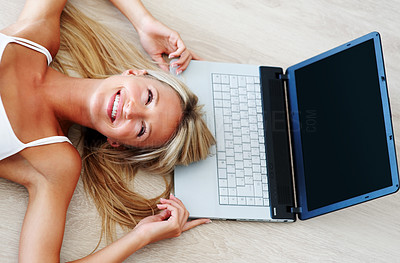 Happy young female lying on floor with laptop