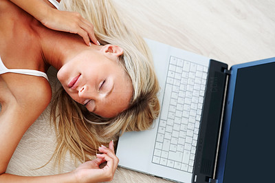 Cute young female sleeping on floor with laptop