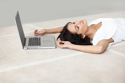 Lovely female lying on the floor besides a laptop