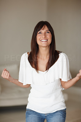 Young woman holding clenched fist in excitement