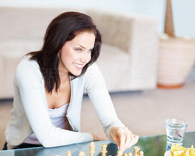 Smiling young woman playing a game of chess