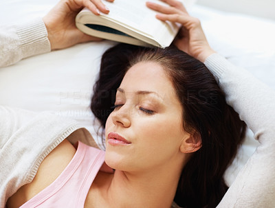 Young female fallen asleep while reading a novel