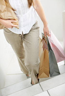 Low section of a woman walking with shopping bags