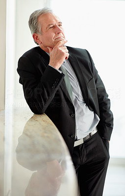 Thoughtful mature business man with hand on chin