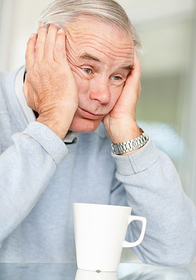 Stressful mature man with a cup of tea or coffee