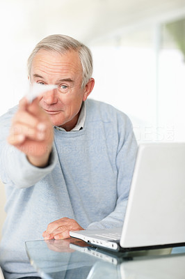 Mature man with laptop and throwing a paper plane
