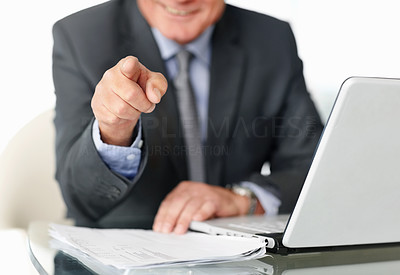 Mature man with laptop pointing towards you