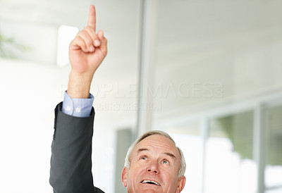 Happy senior business man pointing upwards
