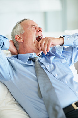 Sleepy elderly business man yawning