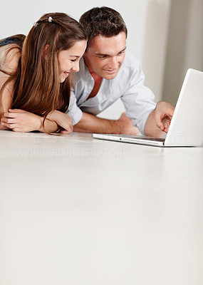 Father showing something interesting to his daughter on laptop