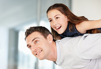 Happy middle aged man giving piggyback ride to a playful girl