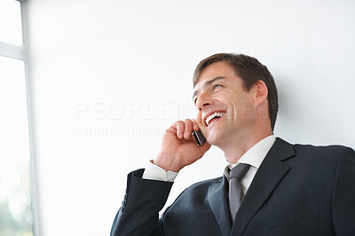 Happy middle aged man talking on mobile phone with copyspace