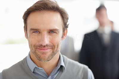 Smiling middle aged man with blurred people in background