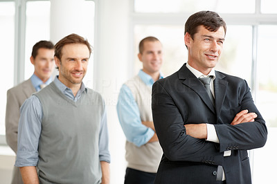 Thoughtful business manager with his team in background
