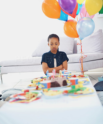 Unhappy girl sitting alone at her birthday party