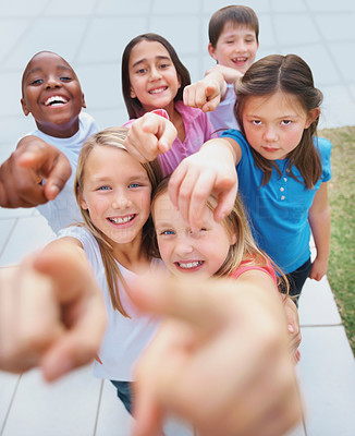Portrait of smiling little kids pointing at you
