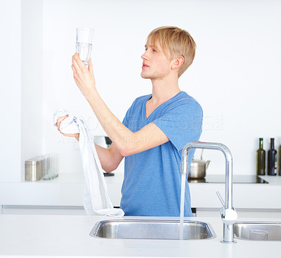 Young boy looking at the glass of water in the kitchen