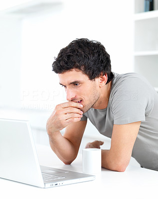 Young male thinking over a laptop
