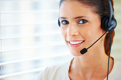 Closeup of a beautiful smiling woman talking on head phone