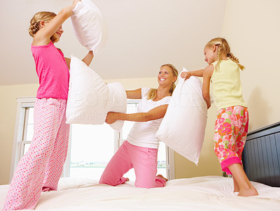 Mother and daughters having a pillow fight