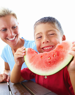 Young mother with son eating watermelon slice