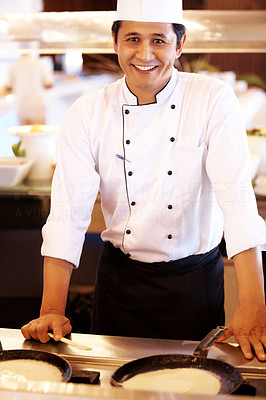Confident male cook in kitchen smiling