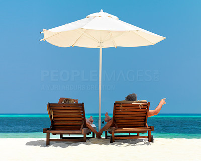 Couple on deck chairs relaxing on the beach