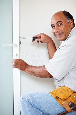 Happy carpenter fixing a lock in a door