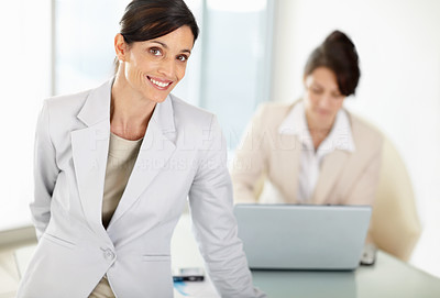 Middle aged business woman with blur colleague in background