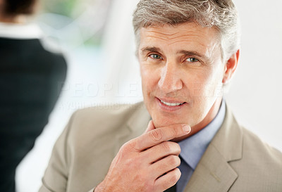 Thoughtful mature business man with hands on chin