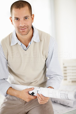 Handsome middle aged architect holding blueprint at office